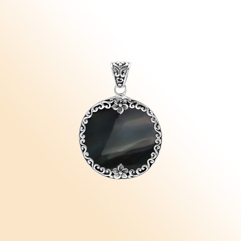 Sterling silver round pendant with glossy black shell and floral Bali detailing, handcrafted artisan jewelry for elegant everyday wear.