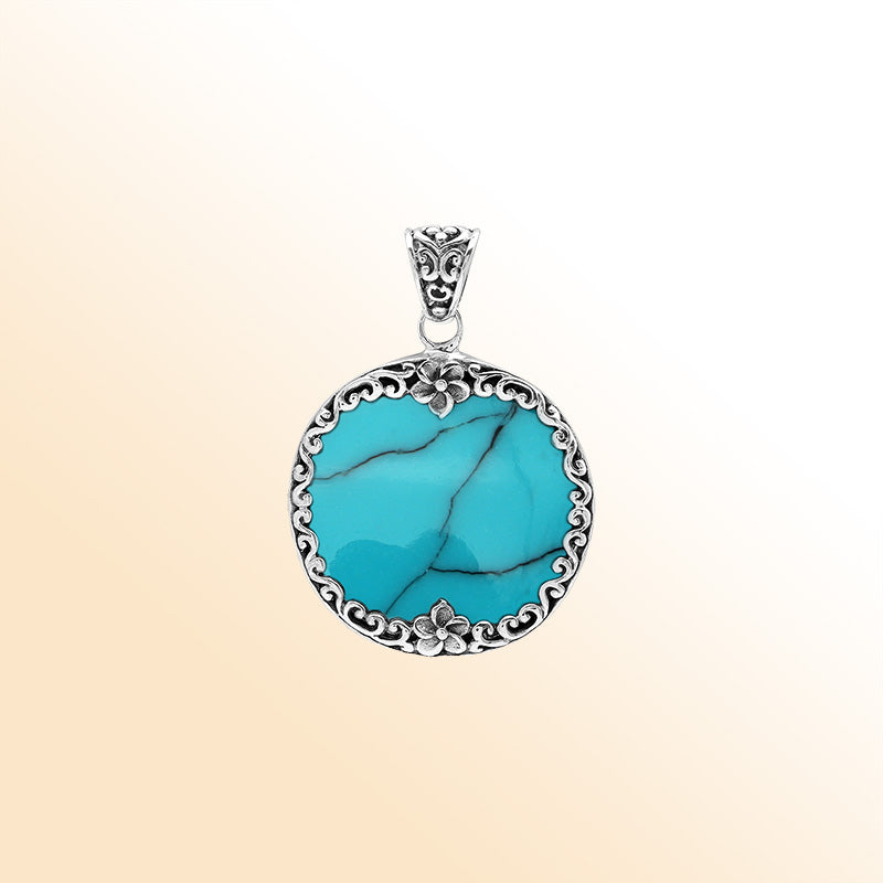Handmade round turquoise pendant in sterling silver with floral Balinese detailing, elegant artisan jewelry for women.