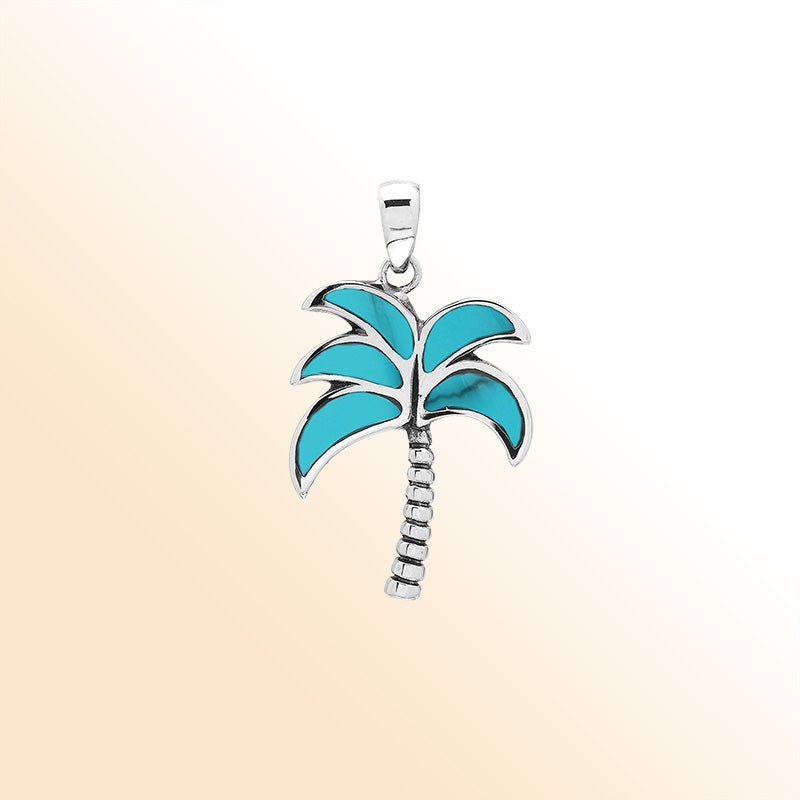 Vibrant sterling silver palm tree pendant with turquoise shell inlay and textured trunk, artisan-crafted for tropical beach style.