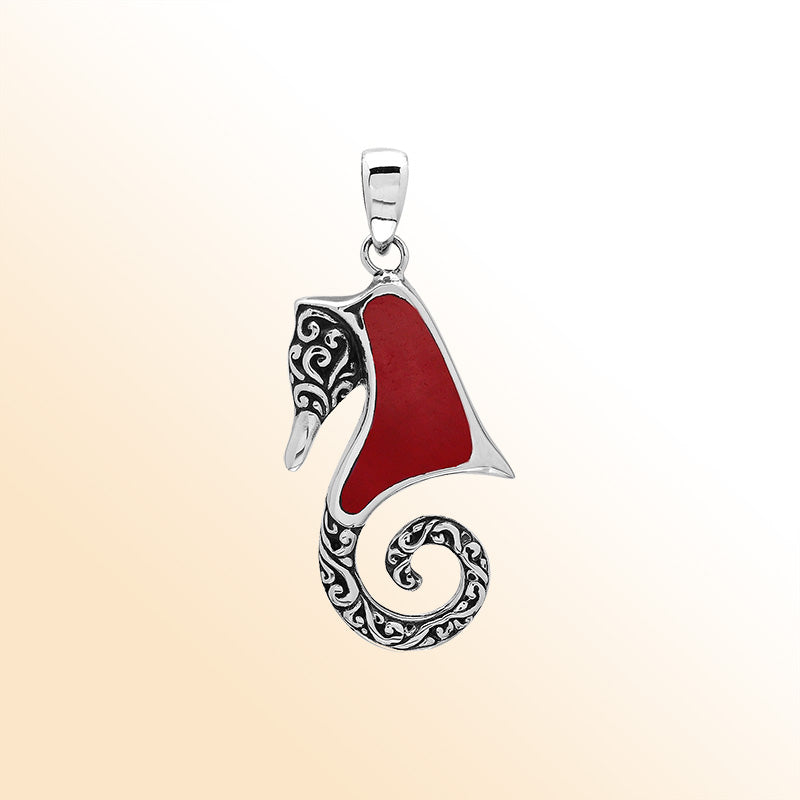 Bold sterling silver seahorse pendant with coral inlay, artisan-crafted for tropical ocean-inspired style.