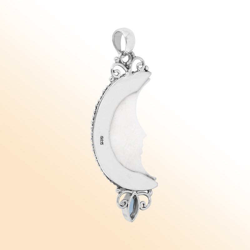 Crescent moon face pendant in sterling silver with carved bone and sparkling blue topaz quartz accent, handmade in Bali.