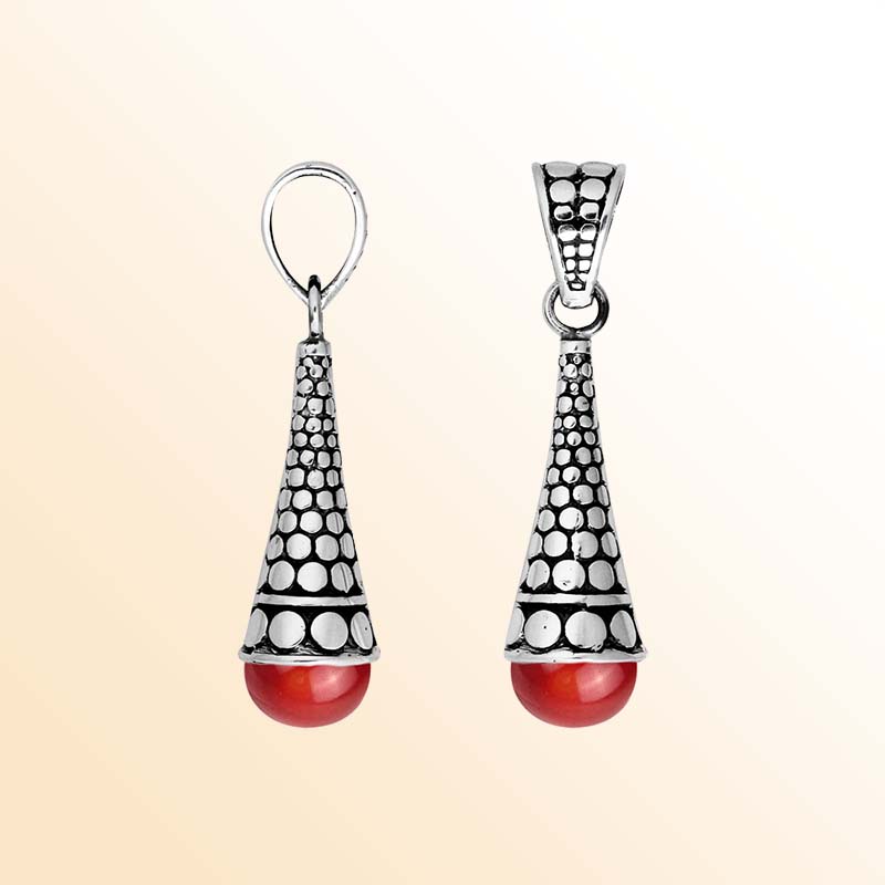 Handcrafted sterling silver red coral pendant featuring traditional Indonesian dot-work and oxidized finish.