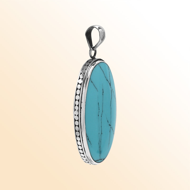 Sterling silver oval pendant with turquoise shell and hammered silver frame handcrafted in Bali