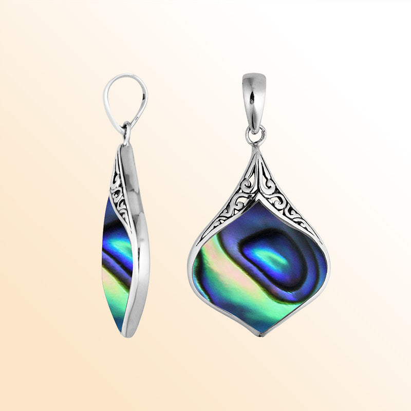 Handcrafted sterling silver pendant featuring a genuine abalone shell with shimmering blue, green, and purple tones framed in intricate Bali design – elegant ocean-inspired jewelry gift.