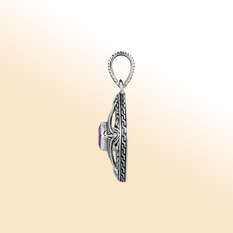 An elegant sterling silver pendant featuring a radiant Amethyst Quartz at the center of an ornate Balinese filigree design, handcrafted with intricate detail.