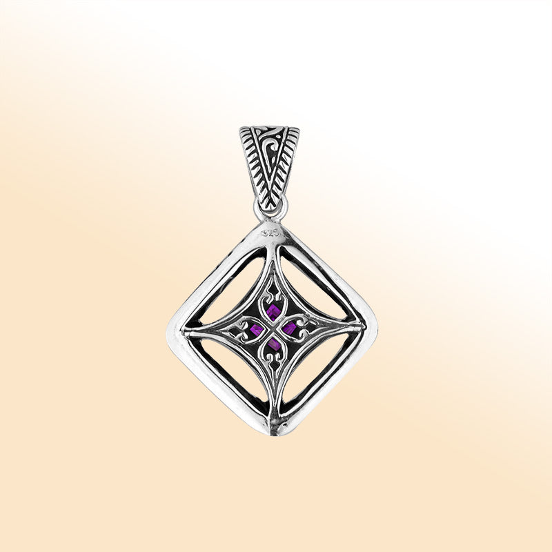 An elegant sterling silver pendant featuring a radiant Amethyst Quartz at the center of an ornate Balinese filigree design, handcrafted with intricate detail.