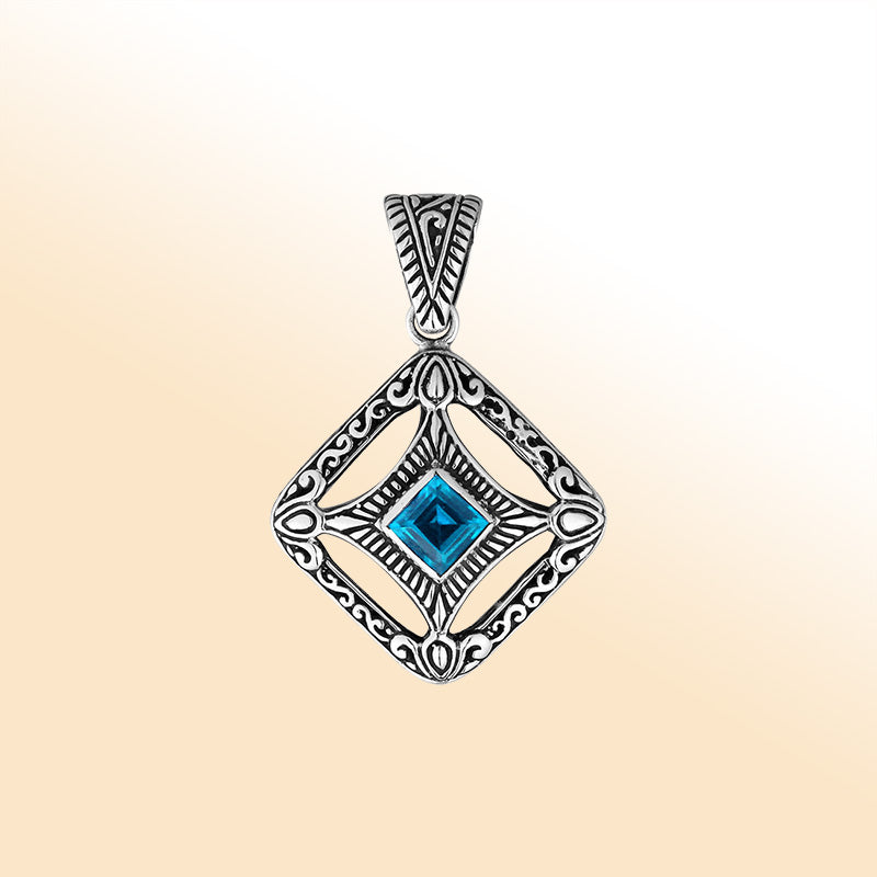 An elegant sterling silver pendant featuring a vivid Blue Topaz Quartz in an ornate Balinese filigree frame, handcrafted with refined silver artistry.