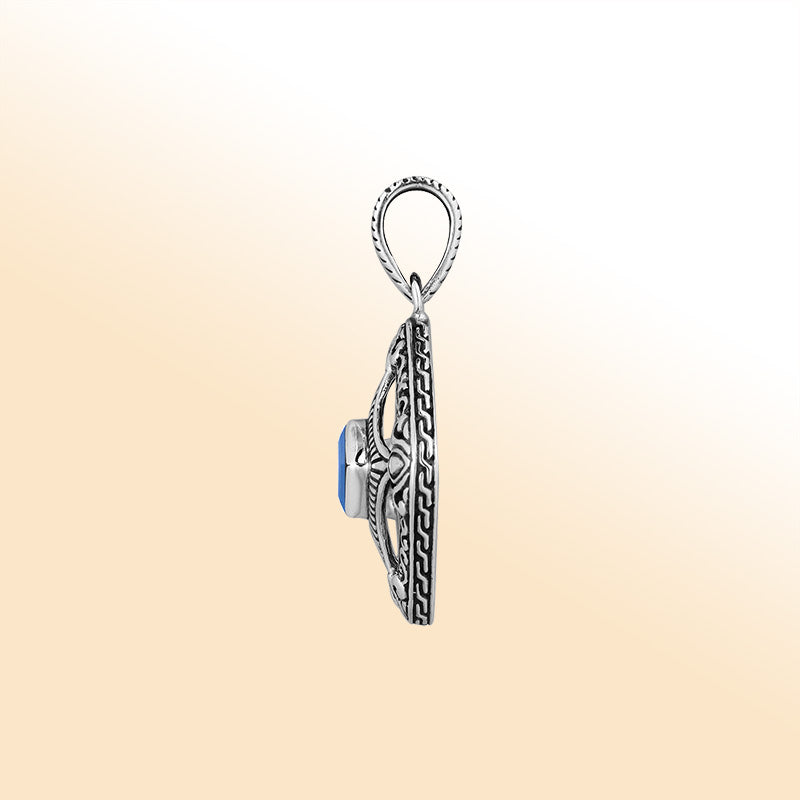 An elegant sterling silver pendant featuring a vivid Blue Topaz Quartz in an ornate Balinese filigree frame, handcrafted with refined silver artistry.