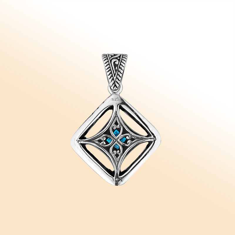 An elegant sterling silver pendant featuring a vivid Blue Topaz Quartz in an ornate Balinese filigree frame, handcrafted with refined silver artistry.