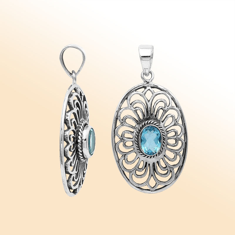 An elegant sterling silver oval pendant featuring Blue Topaz Quartz with detailed Balinese filigree design and polished craftsmanship.