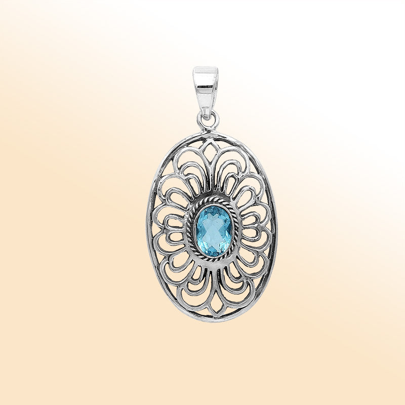 An elegant sterling silver oval pendant featuring Blue Topaz Quartz with detailed Balinese filigree design and polished craftsmanship.
