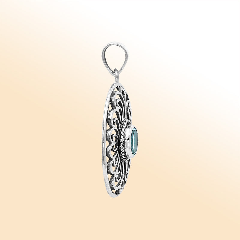 An elegant sterling silver oval pendant featuring Blue Topaz Quartz with detailed Balinese filigree design and polished craftsmanship.