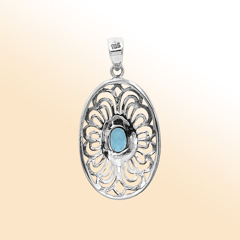An elegant sterling silver oval pendant featuring Blue Topaz Quartz with detailed Balinese filigree design and polished craftsmanship.