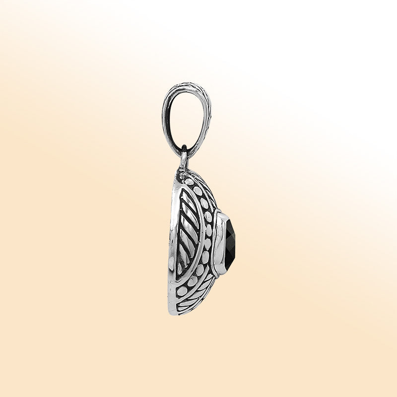 Handcrafted sterling silver pendant with cushion black onyx quartz, detailed leaf engravings, dotted textures, and high-polish finish reflecting Balinese craftsmanship.
