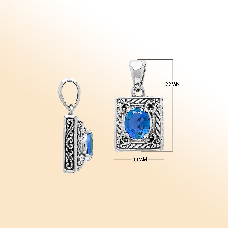 Handcrafted sterling silver pendant with oval blue topaz quartz, ornate swirl engraving, and polished finish showcasing fine Balinese artistry.