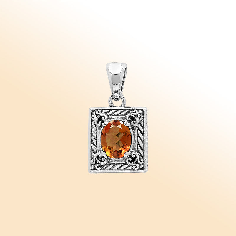 Handcrafted sterling silver pendant with oval citrine quartz, detailed swirl engraving, and mirror-polished surface showcasing Balinese artistry.