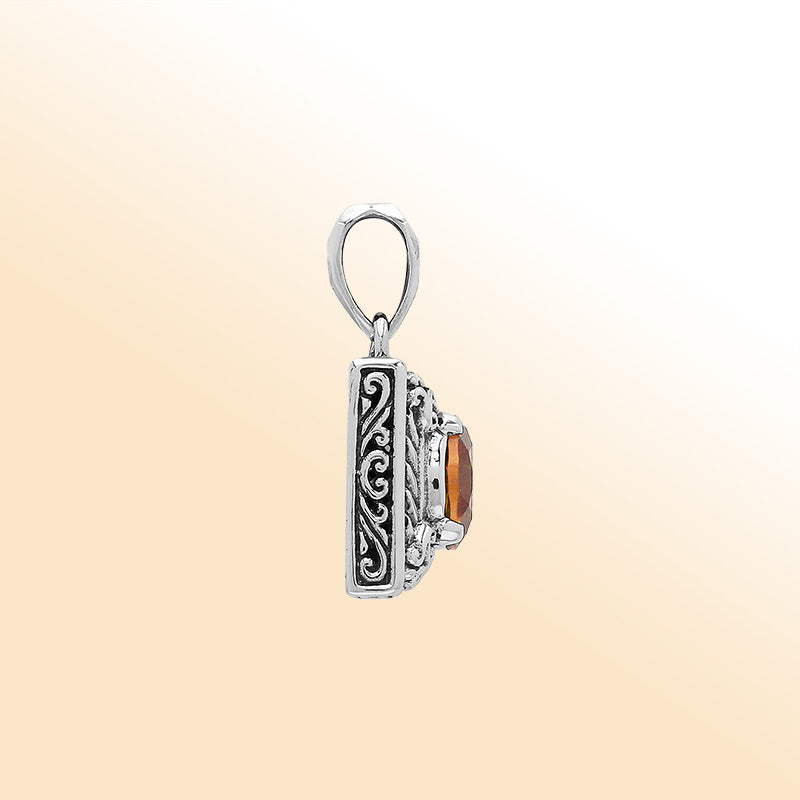 Handcrafted sterling silver pendant with oval citrine quartz, detailed swirl engraving, and mirror-polished surface showcasing Balinese artistry.