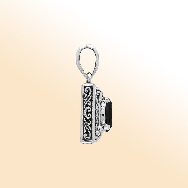 Handcrafted sterling silver pendant featuring oval black onyx quartz, ornate swirl engravings, and smooth polished finish showcasing modern Balinese artistry.