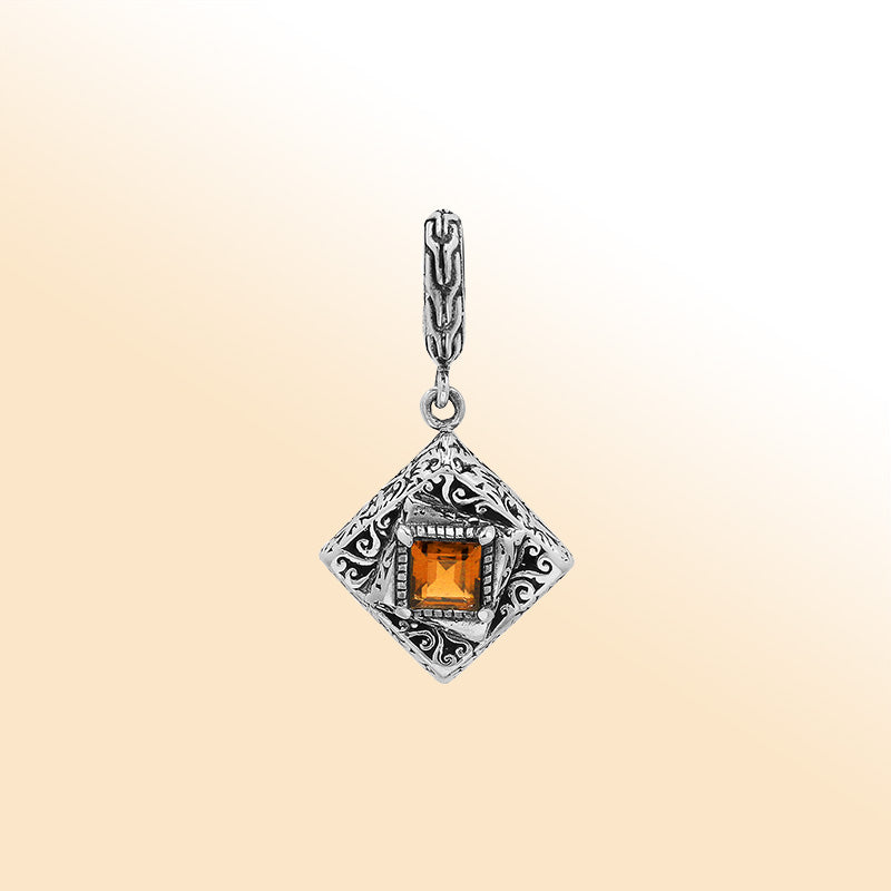 Handcrafted sterling silver pendant with square citrine quartz centerpiece, artistic filigree engravings, and polished finish reflecting Balinese craftsmanship.
