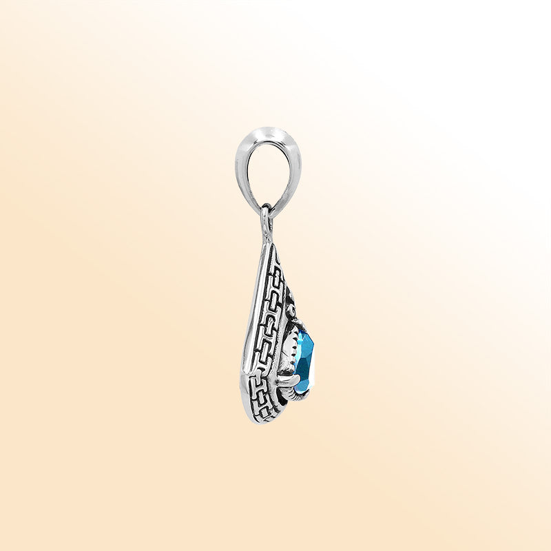 Handcrafted sterling silver triangular pendant with trillion-cut blue topaz quartz, geometric engravings, and high-gloss polished Balinese detailing.
