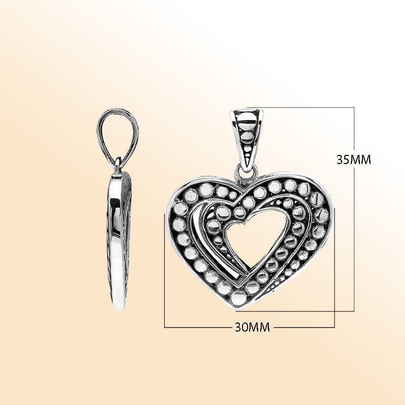 Handcrafted sterling silver heart-shaped pendant with layered open-heart design, dotted engravings, and oxidized Balinese detailing.