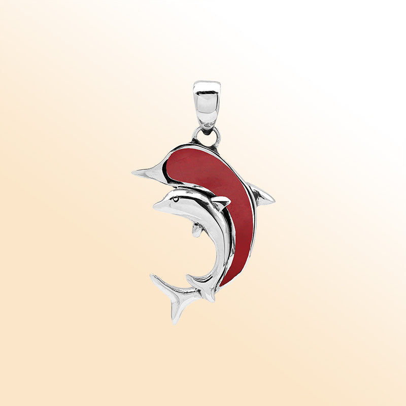 Elegant sterling silver dolphin pendant with red coral inlay and Balinese craftsmanship in a high-polish ocean-inspired design.