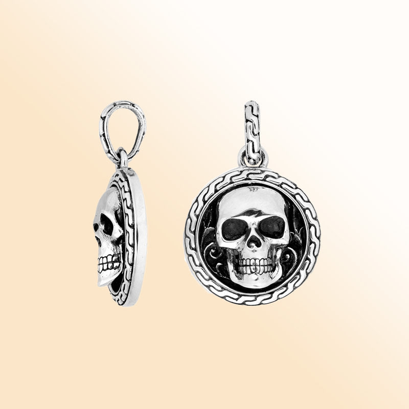 Artisan sterling silver skull pendant with carved border and polished finish.