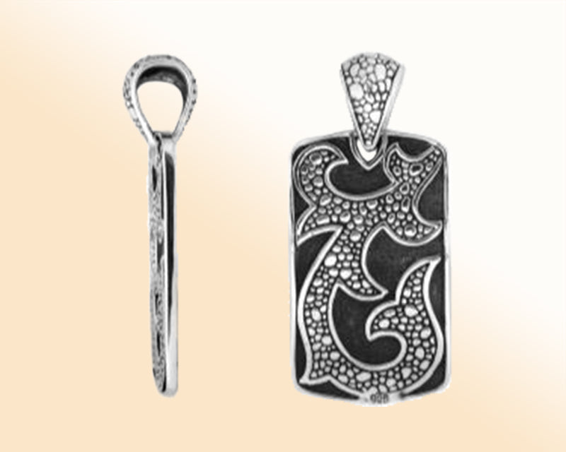 Artistic sterling silver rectangle pendant with tribal carved detailing.