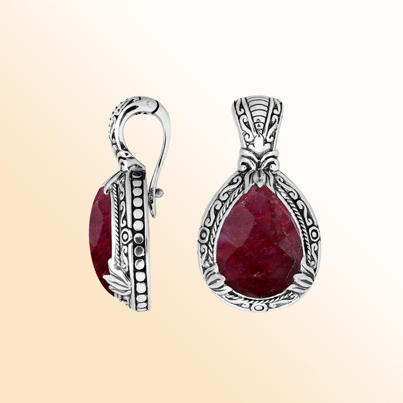 Handcrafted sterling silver pendant featuring a faceted Ruby Quartz teardrop with artistic Balinese detailing and a polished high-gloss finish.