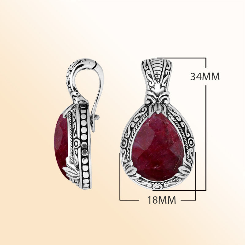 Handcrafted sterling silver pendant featuring a faceted Ruby Quartz teardrop with artistic Balinese detailing and a polished high-gloss finish.