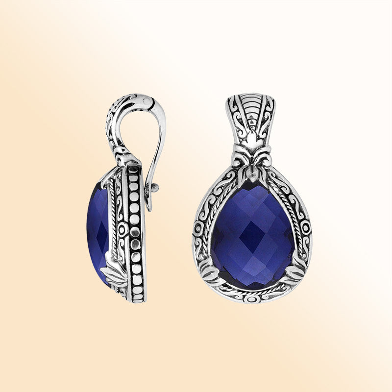 Handcrafted sterling silver pendant featuring a faceted Sapphire Quartz teardrop with artistic Balinese detailing and a polished high-gloss surface.