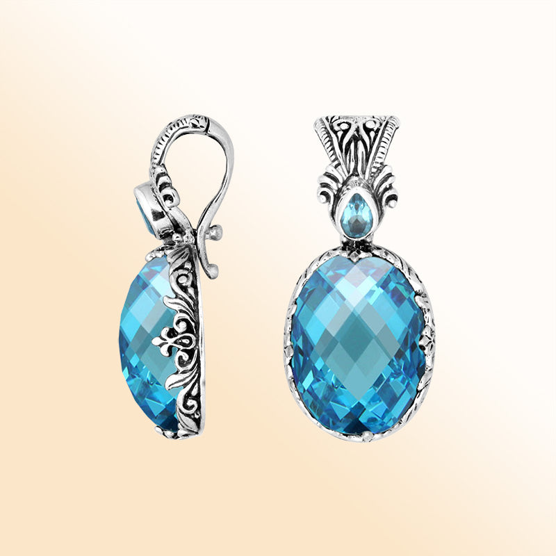 Handcrafted sterling silver pendant featuring an oval Blue Topaz Quartz with artistic Balinese detailing and a polished glossy surface.