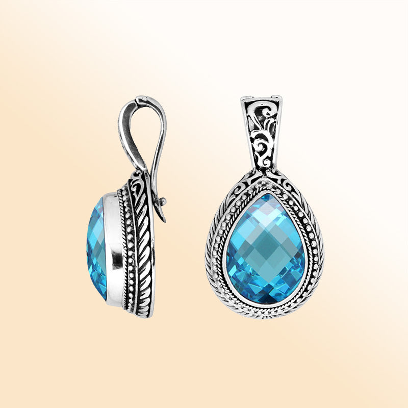 Handcrafted sterling silver teardrop pendant featuring Blue Topaz Quartz with artistic Balinese detailing and a polished high-gloss finish.