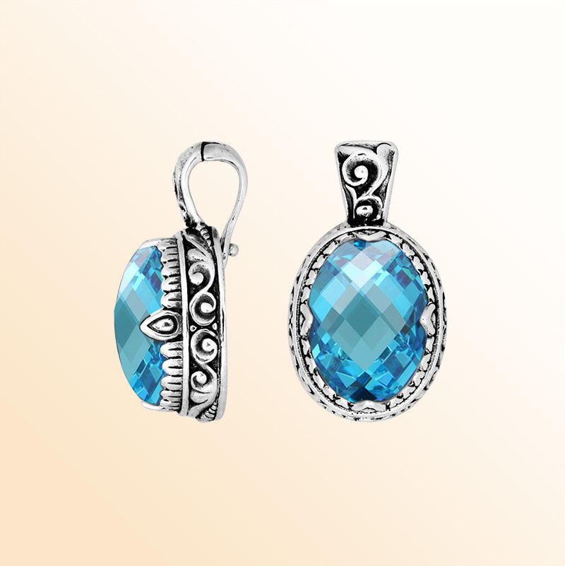 A handcrafted sterling silver pendant featuring an oval Blue Topaz Quartz centerpiece highlighted by artistic scroll carvings and a polished decorative frame for expressive everyday styling.