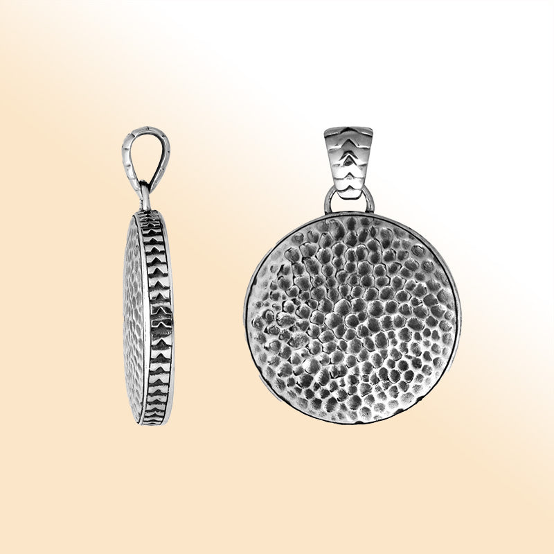 Handcrafted sterling silver round pendant featuring a hammered texture surface with artistic detailing and a polished decorative frame suitable for expressive everyday styling.