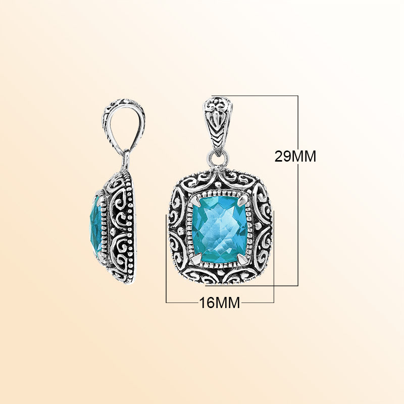 Handcrafted sterling silver cushion pendant featuring a faceted Blue Topaz Quartz centerpiece highlighted by artistic Balinese scroll carvings and a smooth decorative frame.