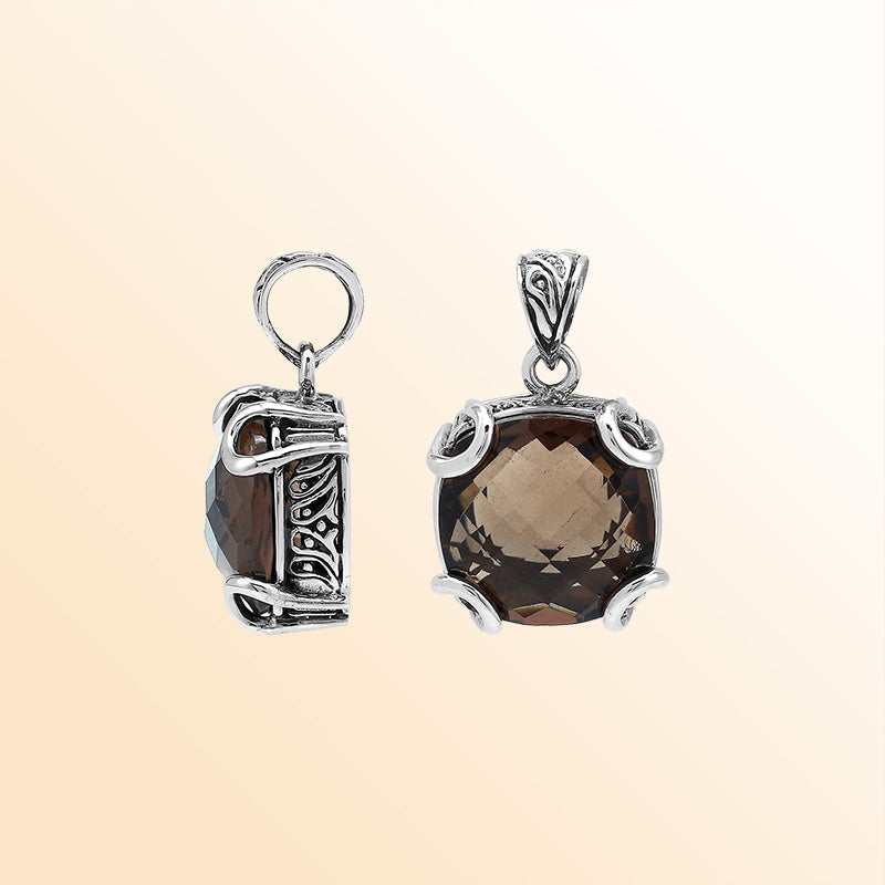 Handcrafted sterling silver cushion pendant featuring a faceted Smokey Quartz centerpiece accentuated with artistic prong work and carved Balinese decorative motifs.