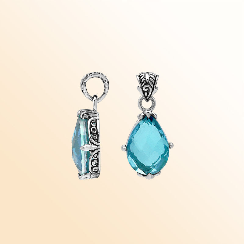 Handcrafted sterling silver pear-shaped pendant featuring a faceted Blue Topaz Quartz center with expressive prong work and detailed Balinese carved embellishments.