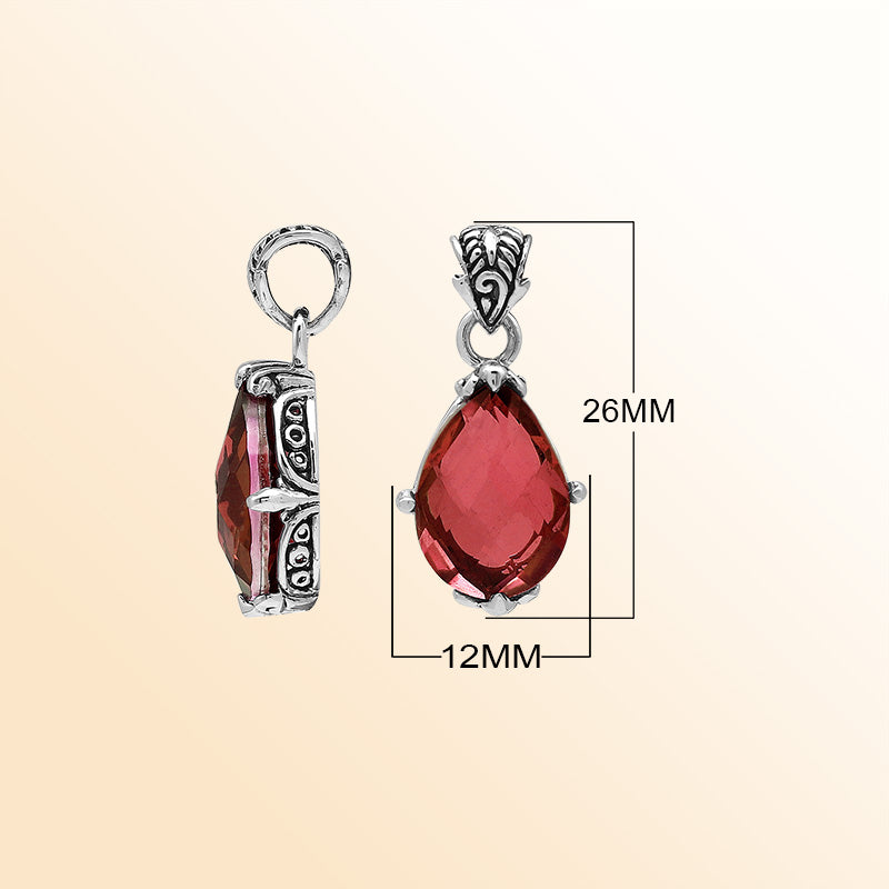 Handcrafted sterling silver pear-shaped pendant featuring a faceted Red Garnet Quartz centerpiece with expressive prong work and decorative Balinese carved detailing.