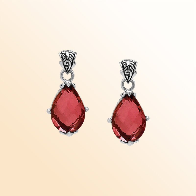 Handcrafted sterling silver pear-shaped pendant featuring a faceted Red Garnet Quartz centerpiece with expressive prong work and decorative Balinese carved detailing.