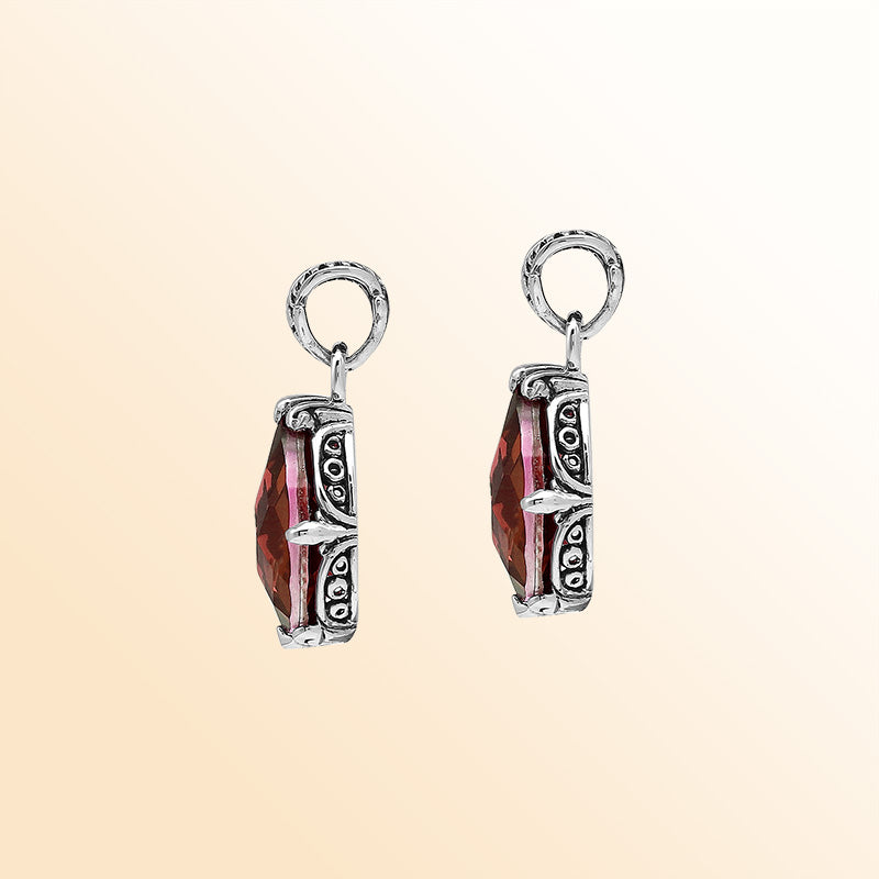 Handcrafted sterling silver pear-shaped pendant featuring a faceted Red Garnet Quartz centerpiece with expressive prong work and decorative Balinese carved detailing.