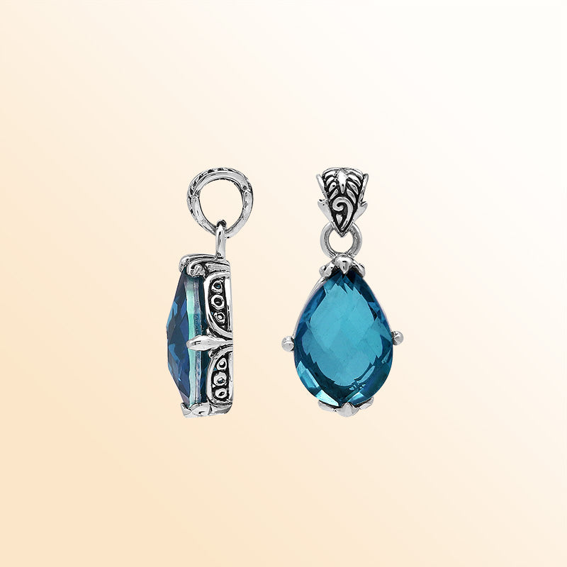 Handcrafted sterling silver pear-shaped pendant featuring a faceted London Blue Topaz Quartz centerpiece with expressive prong-setting and intricate Balinese carved accents.