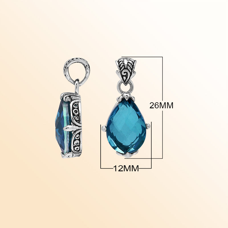 Handcrafted sterling silver pear-shaped pendant featuring a faceted London Blue Topaz Quartz centerpiece with expressive prong-setting and intricate Balinese carved accents.