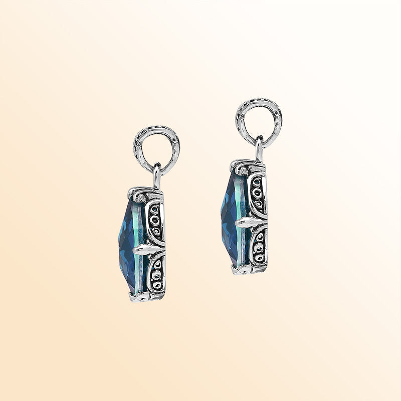 Handcrafted sterling silver pear-shaped pendant featuring a faceted London Blue Topaz Quartz centerpiece with expressive prong-setting and intricate Balinese carved accents.