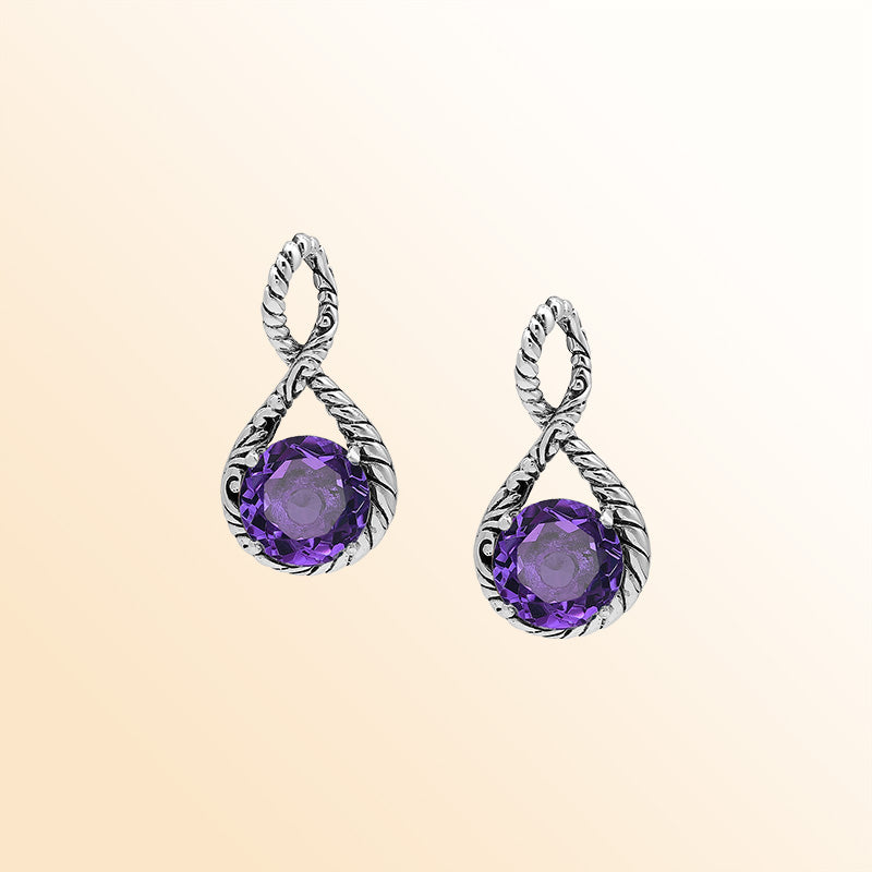 Handcrafted sterling silver twisted loop pendant featuring a round faceted Amethyst Quartz with artistic engraved detailing and expressive Balinese styling.