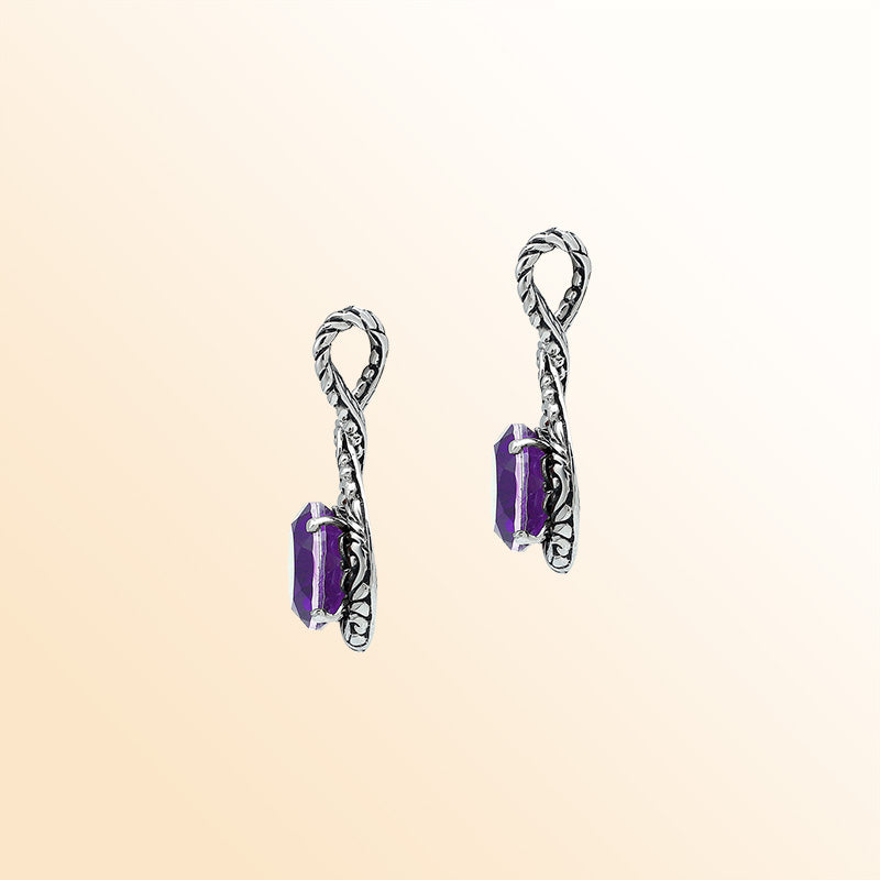 Handcrafted sterling silver twisted loop pendant featuring a round faceted Amethyst Quartz with artistic engraved detailing and expressive Balinese styling.