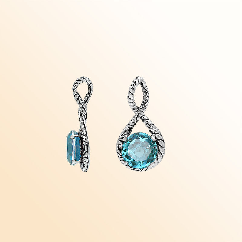 Handcrafted sterling silver twisted loop pendant featuring a faceted Blue Topaz Quartz centerpiece with artistic engraved detailing and Balinese styling.
