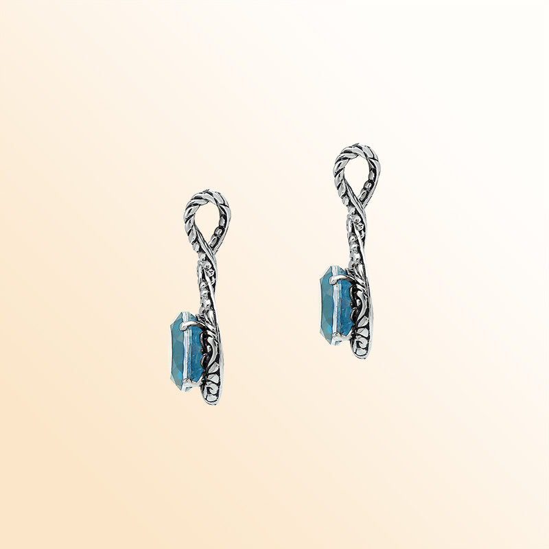 Handcrafted sterling silver twisted loop pendant featuring a faceted Blue Topaz Quartz centerpiece with artistic engraved detailing and Balinese styling.