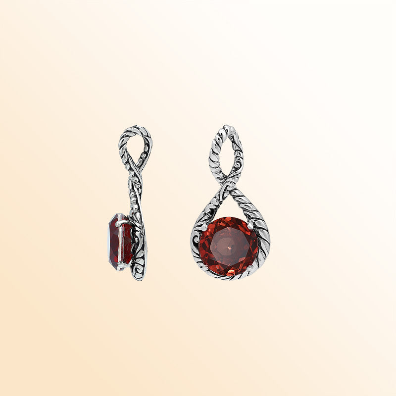 Handcrafted sterling silver twisted loop pendant featuring a round Red Garnet Quartz centerpiece with artistic engraving and expressive Balinese detailing.