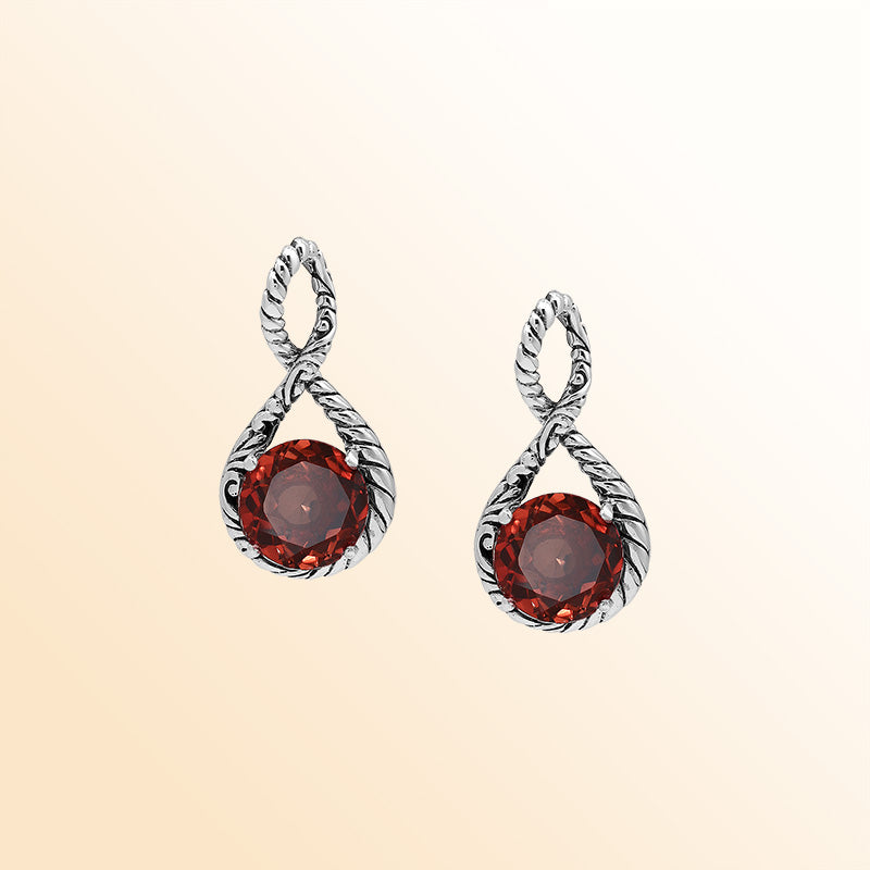 Handcrafted sterling silver twisted loop pendant featuring a round Red Garnet Quartz centerpiece with artistic engraving and expressive Balinese detailing.